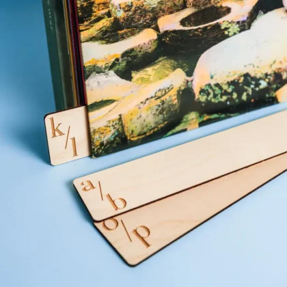 Double-sided engraved wooden vinyl record dividers standing upright in an Ikea Kallax shelf unit