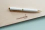 Open botanical wedding guest book showing thick 160gsm white pages with handwritten guest messages