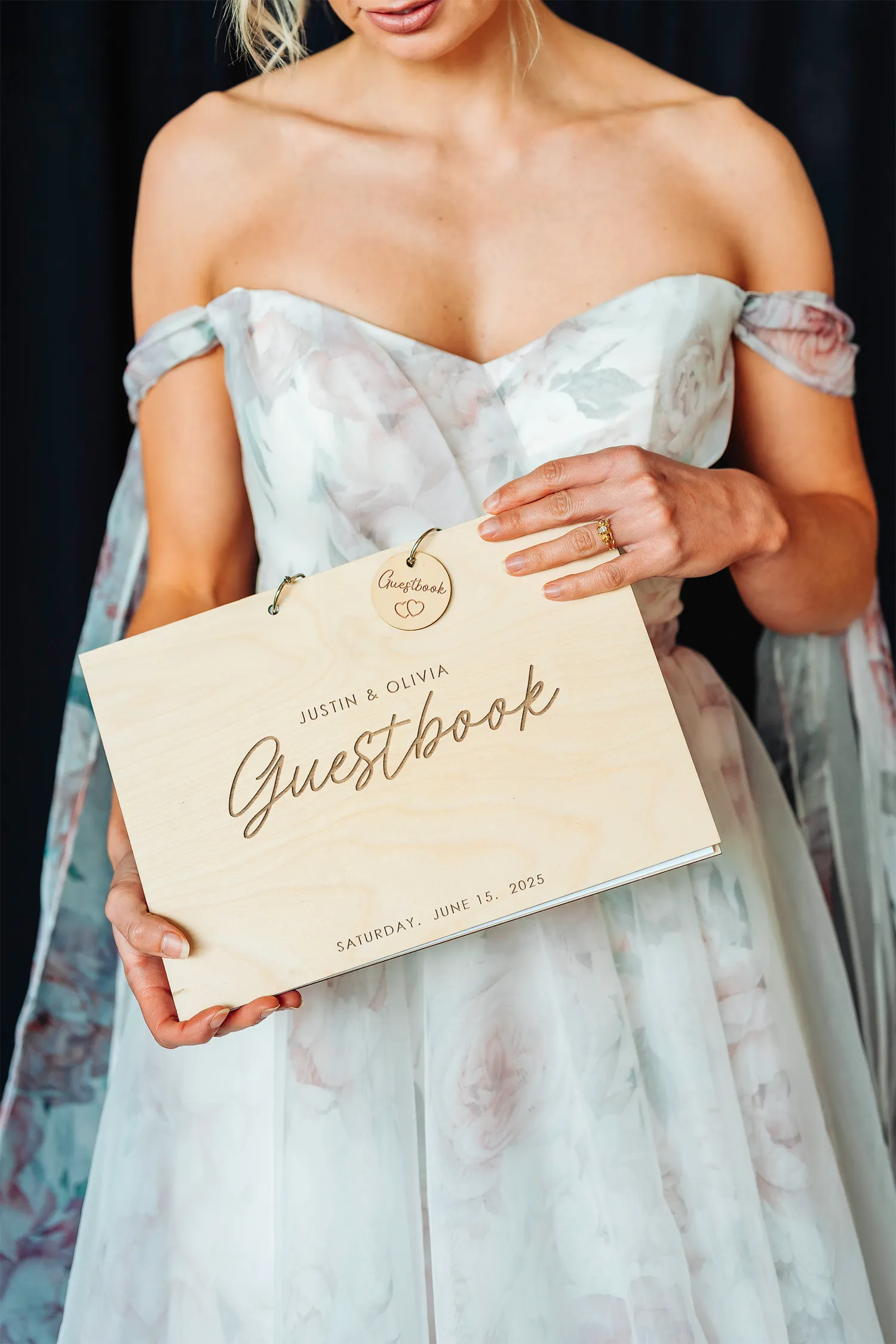 A bride holding a personalised Wedding Guestbook, made from wood