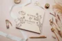 Wildflower engraved wedding guest book open showing thick 160gsm white pages for guest messages