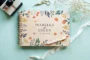 Bold botanical wedding guest book landscape view showing full-colour printed wooden cover and spiral wire binding
