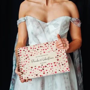 close-up of confetti hearts wooden wedding guest book cover showing engraved names and date
