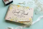 Yellow wildflower wedding guest book square cover close-up showing vibrant colour-printed floral wooden cover