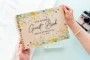 Yellow wildflower wooden wedding guest book landscape view showing full-colour printed cover and spiral binding