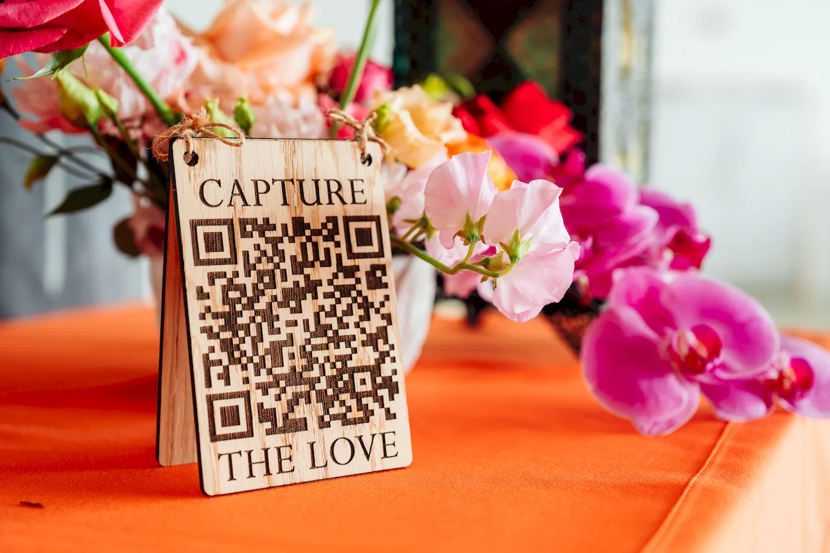 overhead view of capture the love QR code engraved oak sign on white background