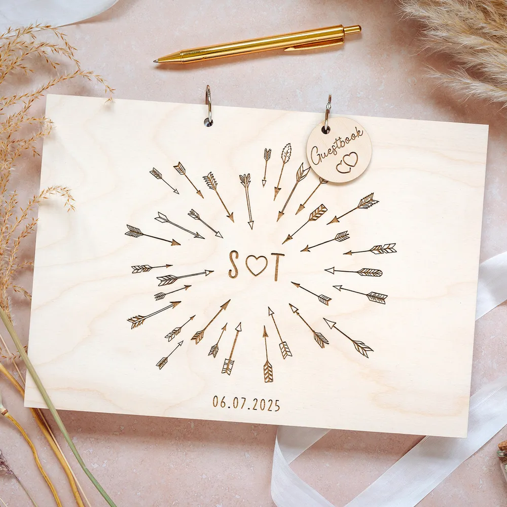 Close-up of laser-engraved wooden wedding guest book cover with couple's names and wedding date