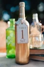 Custom Birch Bottle Table Numbers displayed on a wedding reception table