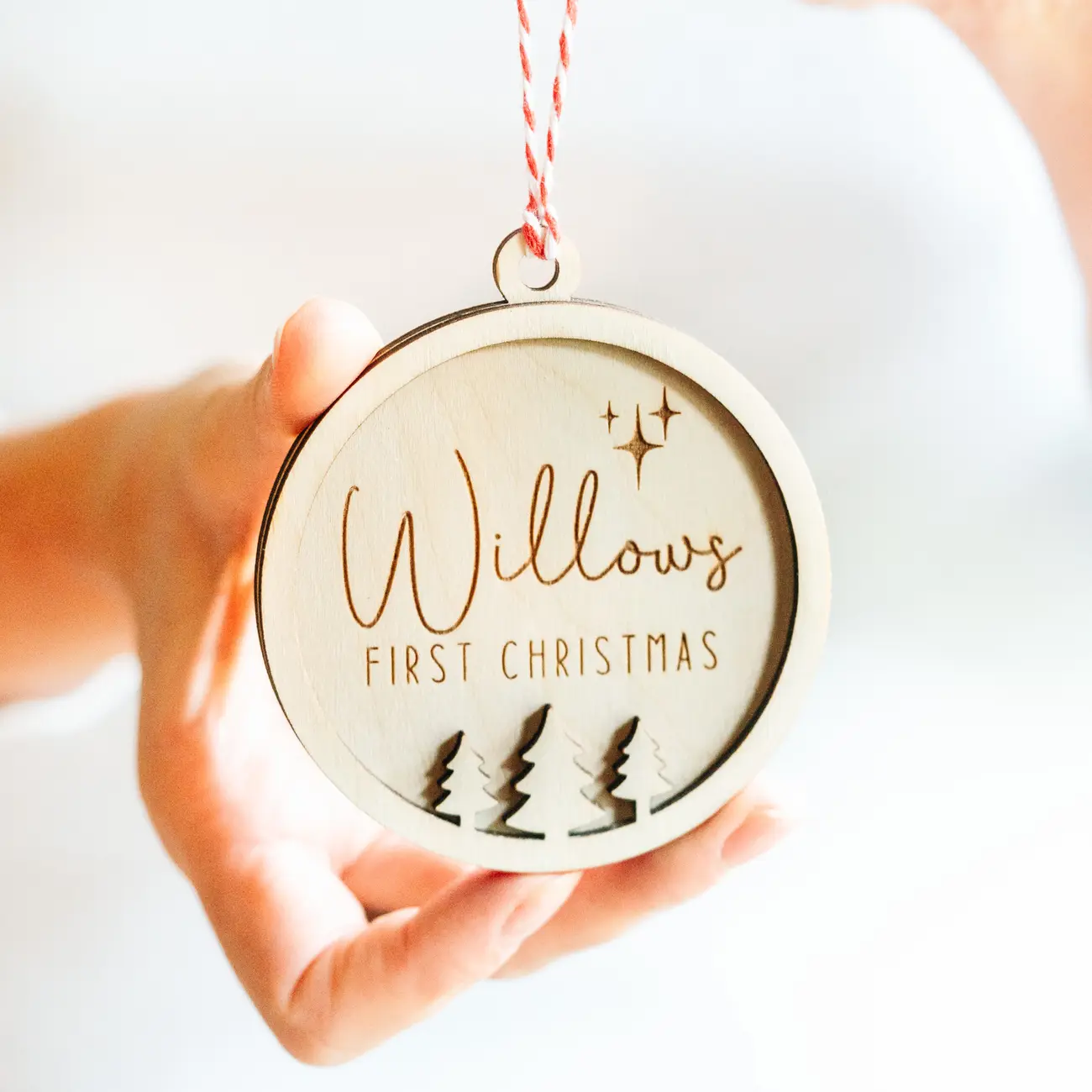 Laser-engraved wooden child's first christmas bauble with ribbon