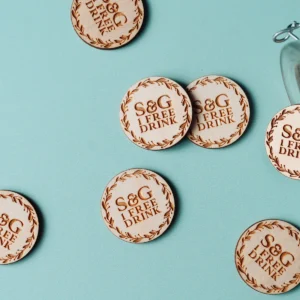 Personalised wooden bar token showing engraved cocktail glass design for wedding or party use