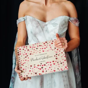 close-up of confetti hearts wooden wedding guest book cover showing engraved names and date