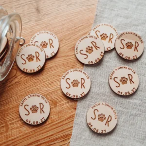 Close-up of personalised paw print wooden wedding drink token with engraved dog paw detail