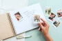 Polaroid photos and handwritten guest messages in the pages of a personalised spiral-bound wooden wedding guest book