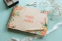 open personalised wooden wedding guest book with handwritten guest messages on white pages