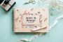 Wildflower border wooden wedding guest book open showing personalised couple names on colour-printed wooden cover