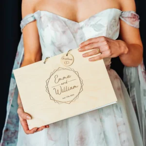 Personalised wooden wedding guest book with engraved love heart design shown on white background