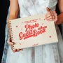 Front cover of retro wedding guest book featuring bold vintage-style red print on natural birch wood with heart and sparkle details