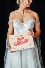 Retro wooden wedding photo guest book held open showing personalised cover with couple's names and wedding date