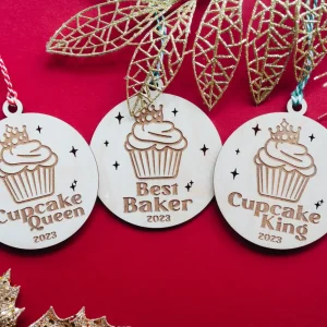 Cupcake Queen, Best Baker and Cupcake King wooden Christmas baubles on a red background with gold leaves